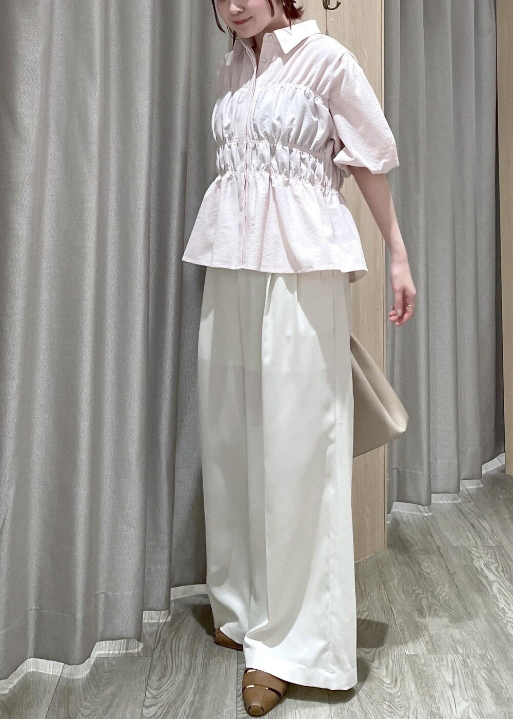 ベージュ系のトートバッグ、ブラウン系のパンプス、ホワイト系のその他パンツを着用したレディースの春コーディネートの5枚目の写真