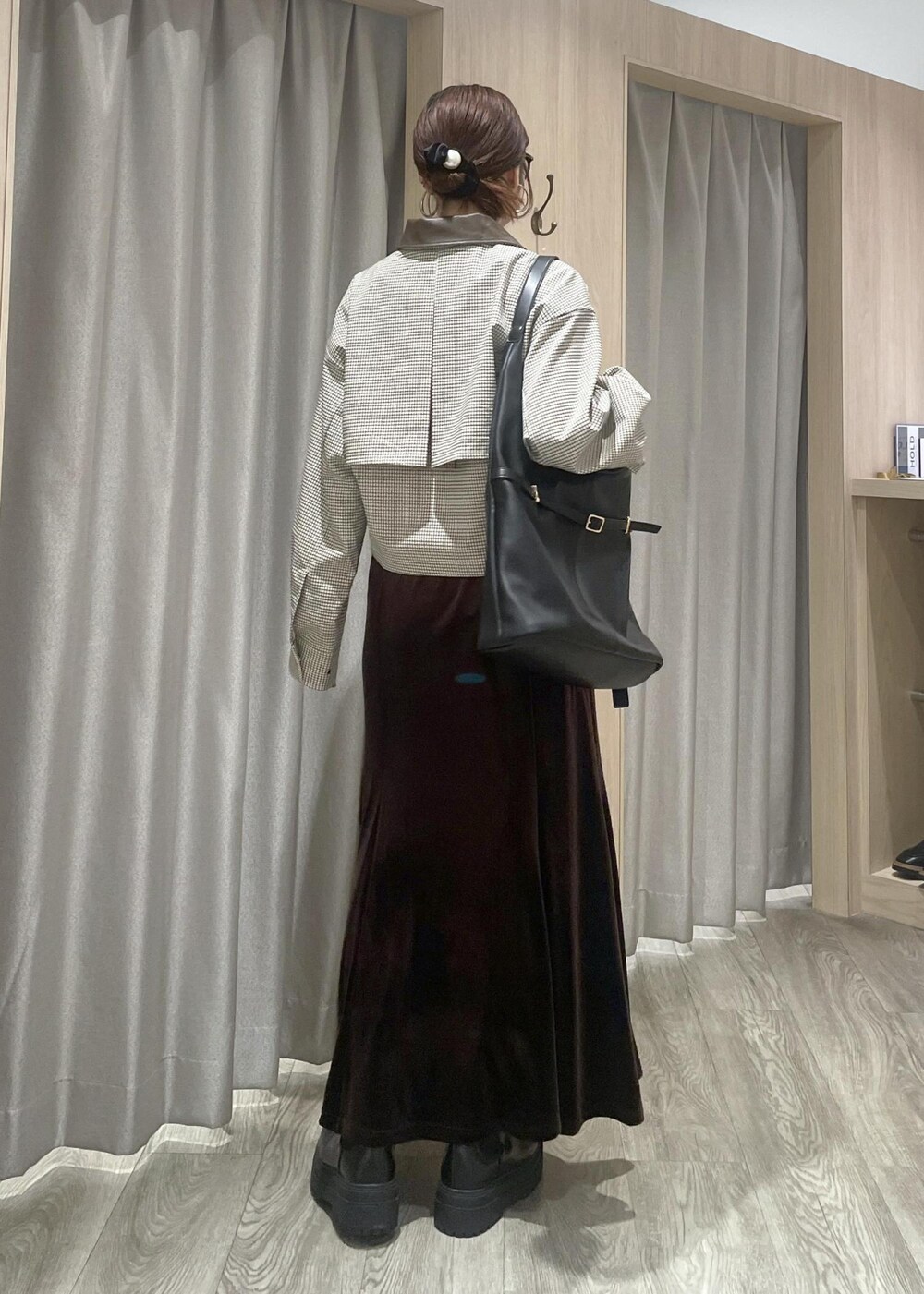 ブラック系のショルダーバッグ、ブラック系のブーツ、ベージュ系のカバーオールを着用したレディースの秋コーディネートの3枚目の写真