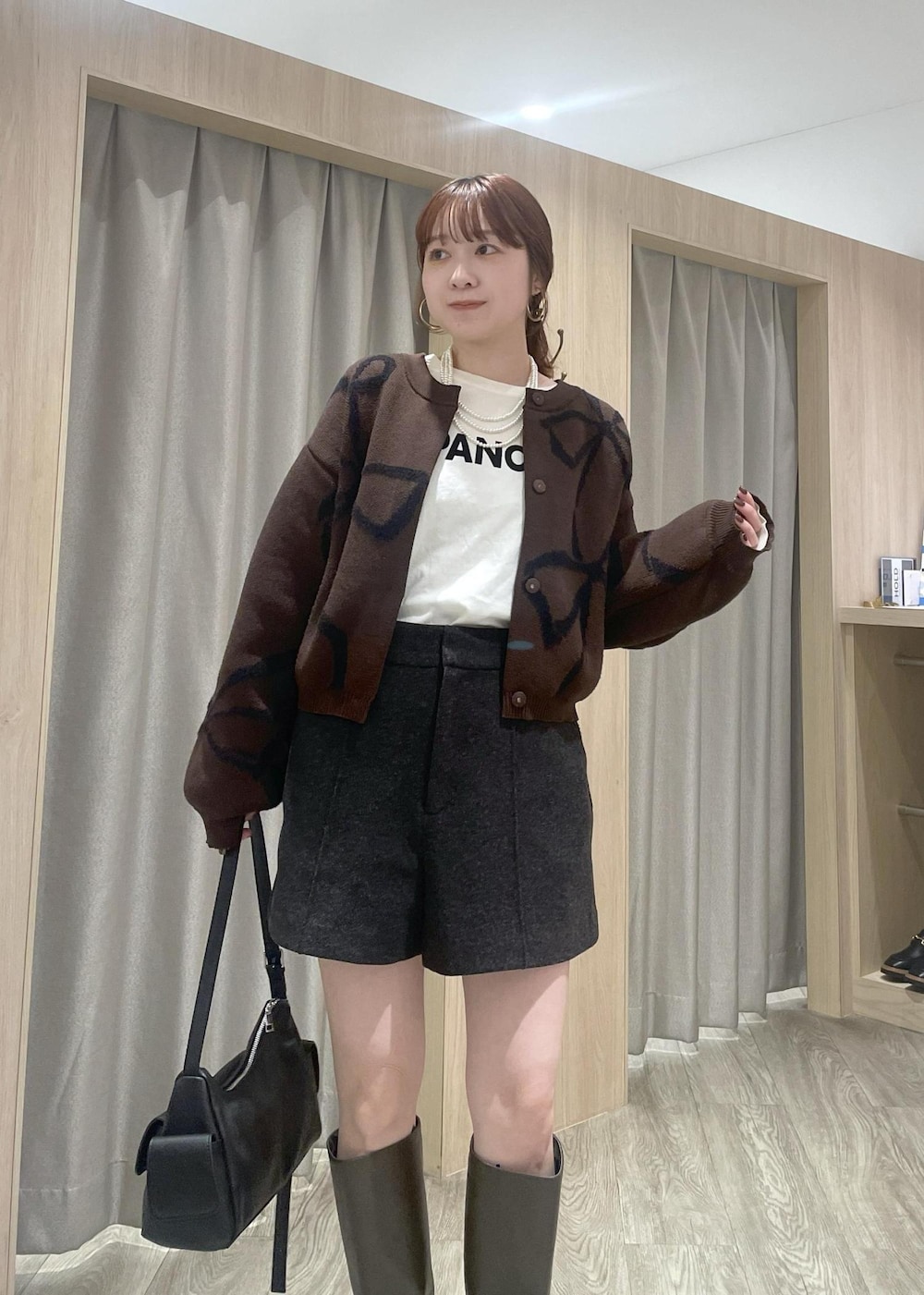 ホワイト系のTシャツ/カットソー、ブラック系のショルダーバッグ、ブラウン系のカーディガン/ボレロを着用したレディースの秋コーディネートの4枚目の写真