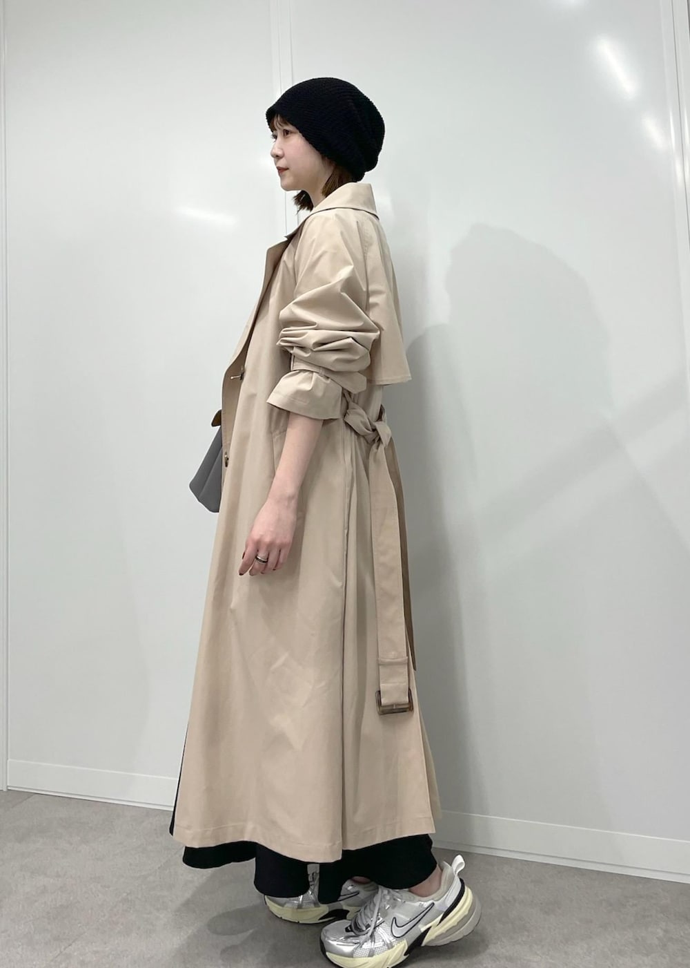 グレー系のハンドバッグ、ブラック系のワンピース、ホワイト系のTシャツ/カットソーを着用したレディースの冬コーディネートの2枚目の写真