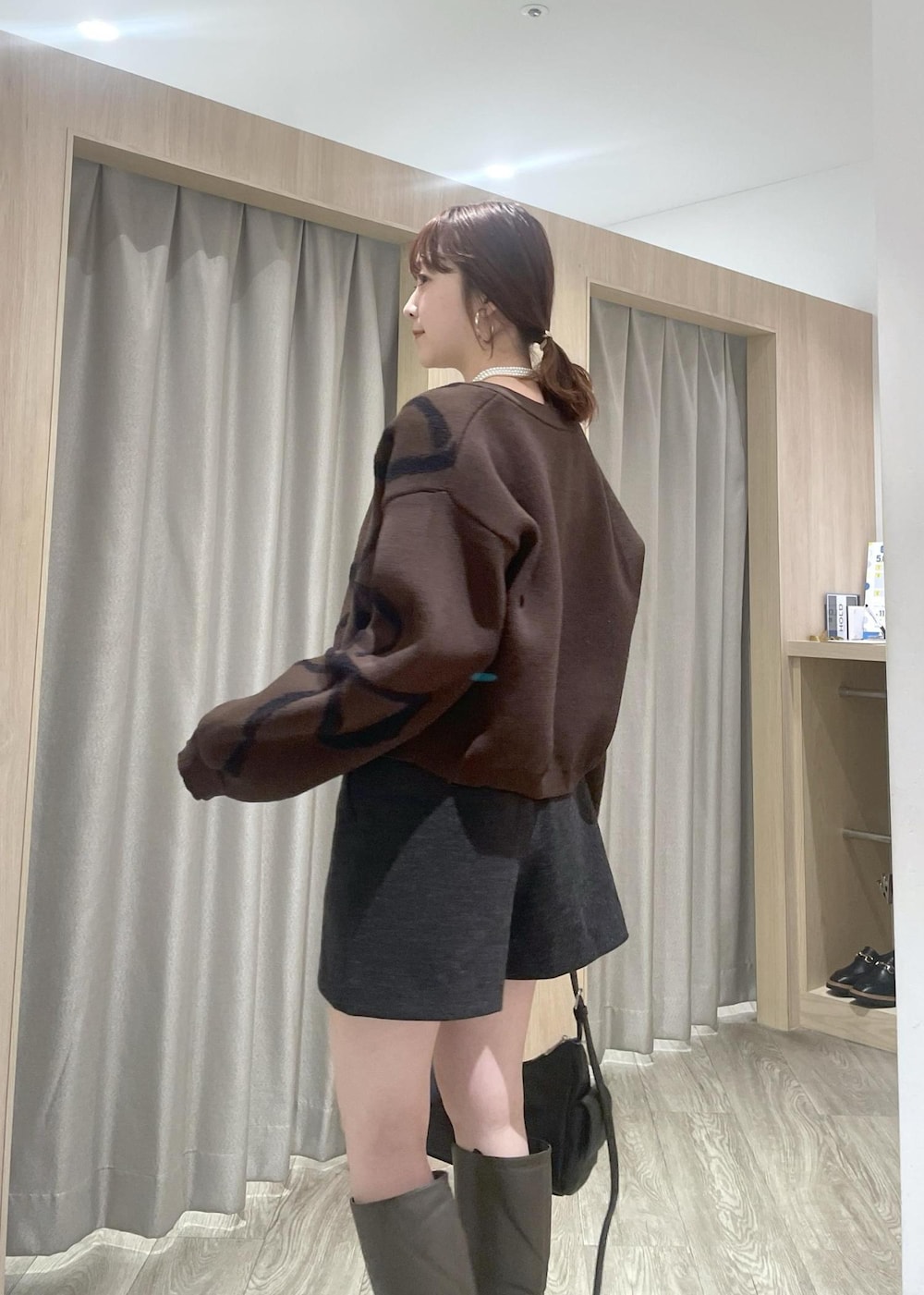 ホワイト系のTシャツ/カットソー、ブラック系のショルダーバッグ、ブラウン系のカーディガン/ボレロを着用したレディースの秋コーディネートの5枚目の写真