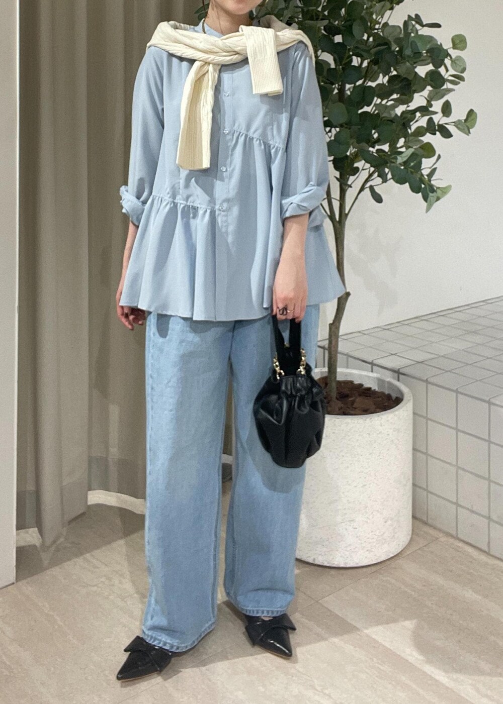 ブラック系のパンプス、ブルー系のシャツ/ブラウス、ホワイト系のカーディガン/ボレロを着用したレディースの冬コーディネートの4枚目の写真