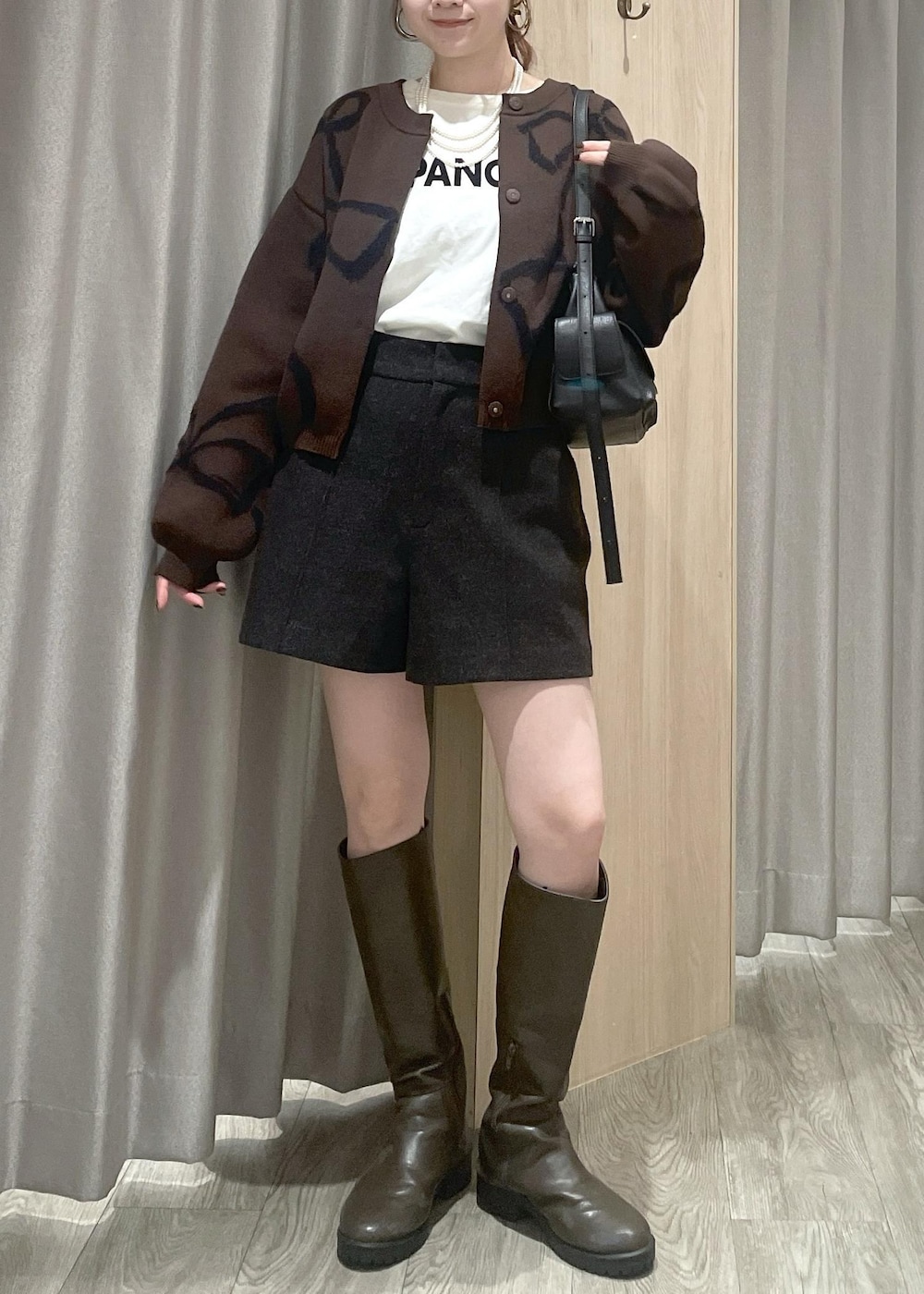 ホワイト系のTシャツ/カットソー、ブラック系のショルダーバッグ、ブラウン系のカーディガン/ボレロを着用したレディースの秋コーディネートの7枚目の写真