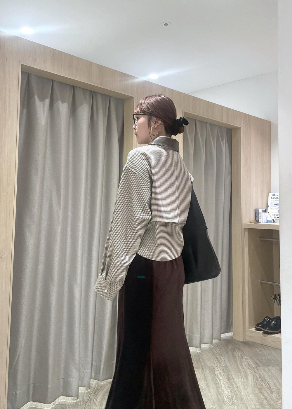 ブラック系のショルダーバッグ、ブラック系のブーツ、ベージュ系のカバーオールを着用したレディースの秋コーディネートの5枚目の写真