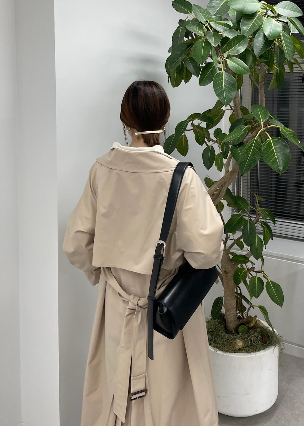 ベージュ系のスラックス、ベージュ系のトレンチコート、ブラック系のショルダーバッグを着用したレディースの冬コーディネートの6枚目の写真