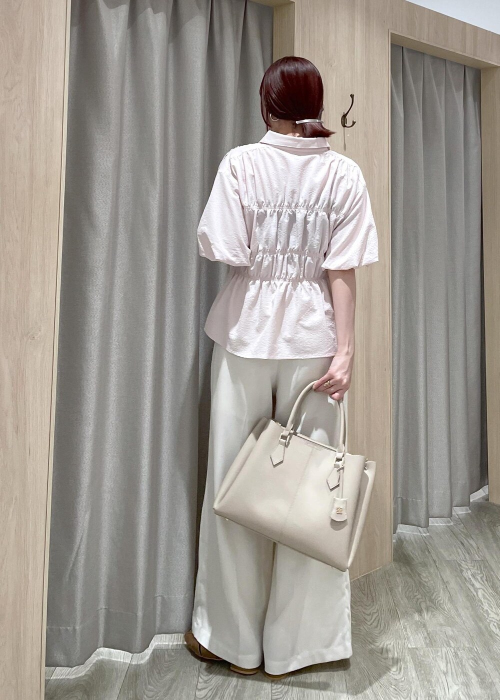 ベージュ系のトートバッグ、ブラウン系のパンプス、ホワイト系のその他パンツを着用したレディースの春コーディネートの3枚目の写真