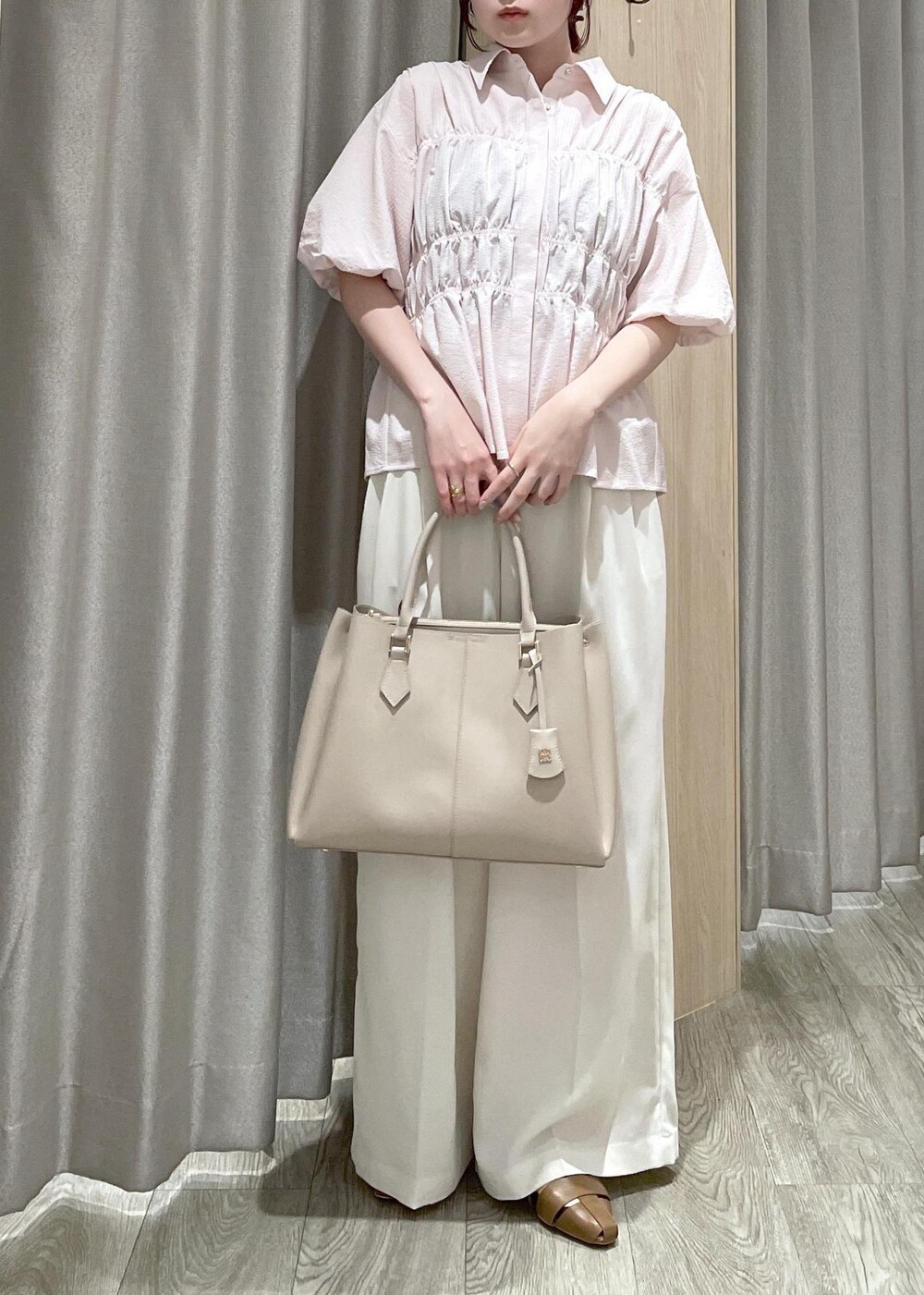 ベージュ系のトートバッグ、ブラウン系のパンプス、ホワイト系のその他パンツを着用したレディースの春コーディネートの4枚目の写真