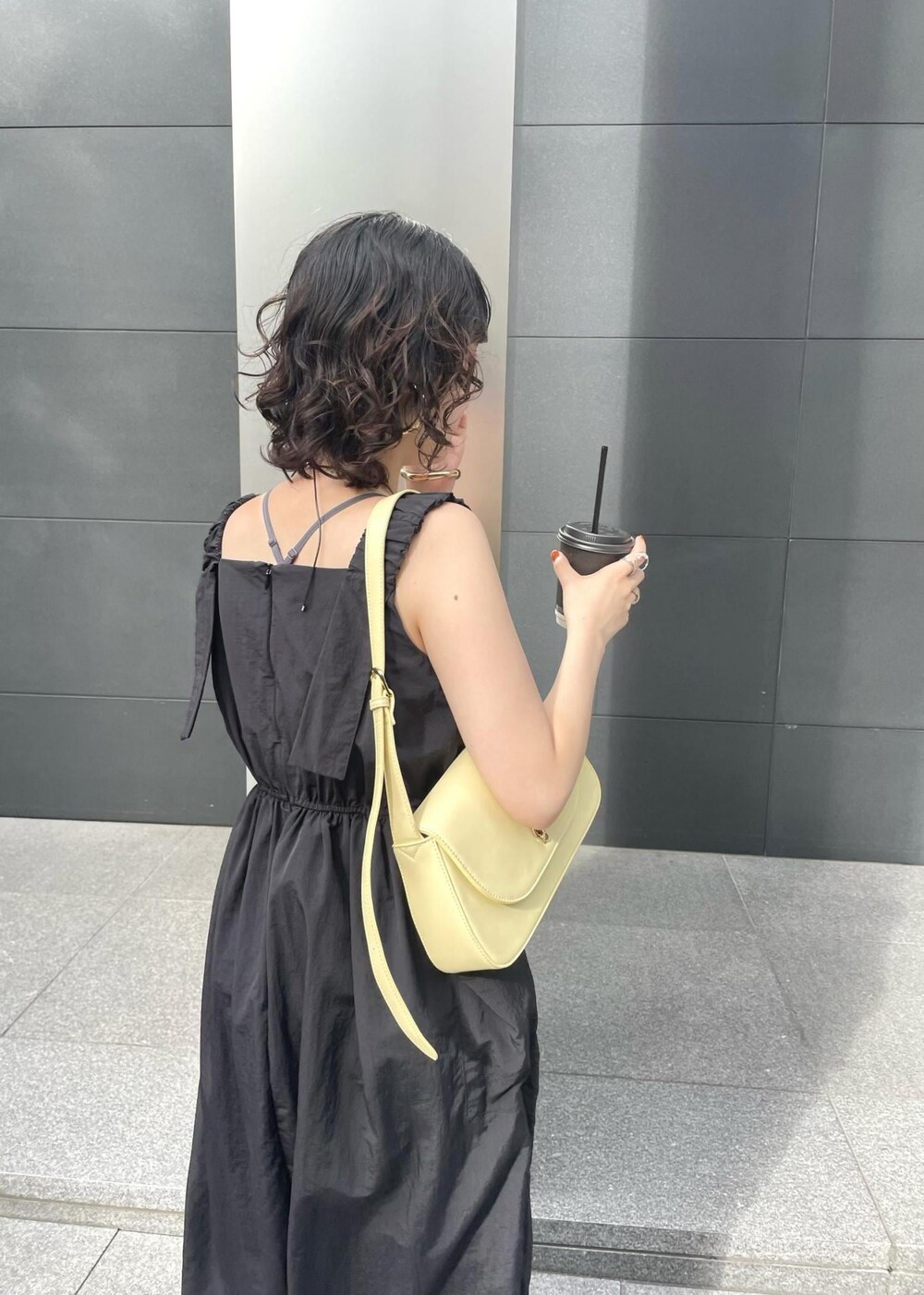 ブラック系のサンダル、ブルー系のデニムパンツを着用したレディースの夏コーディネートの4枚目の写真