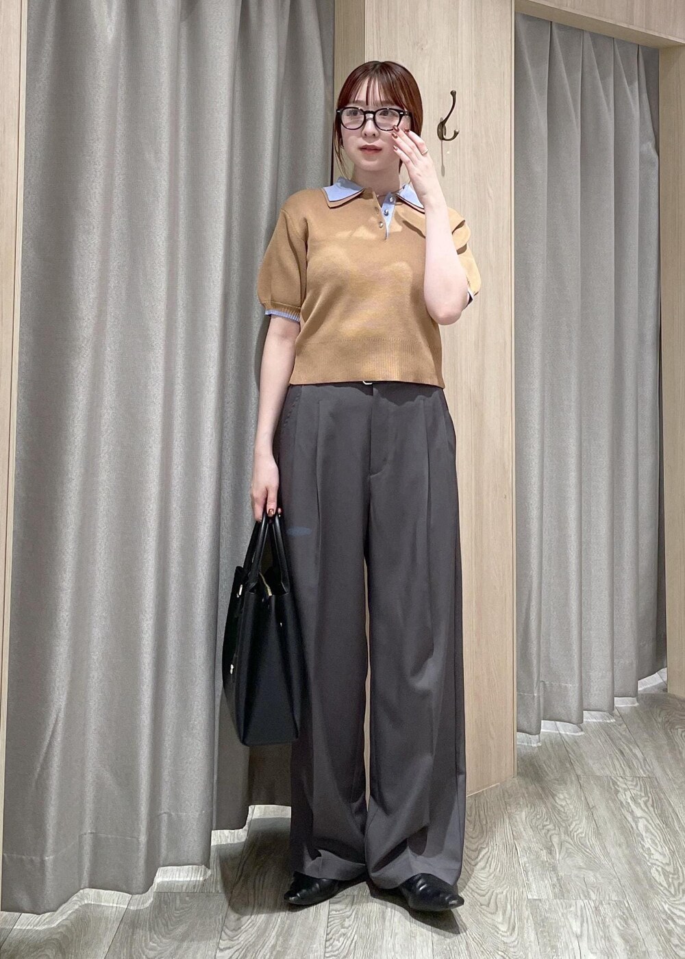 イエロー系のポロシャツ、ブラック系のトートバッグ、グレー系のその他パンツを着用したレディースの春コーディネートの8枚目の写真