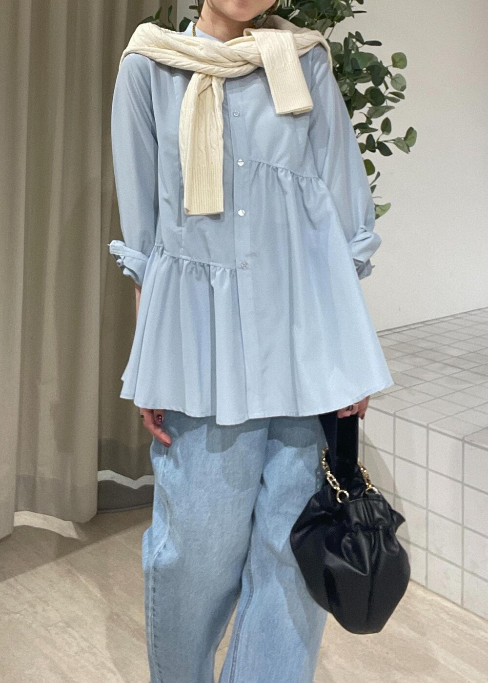 ブラック系のパンプス、ブルー系のシャツ/ブラウス、ホワイト系のカーディガン/ボレロを着用したレディースの冬コーディネートの5枚目の写真