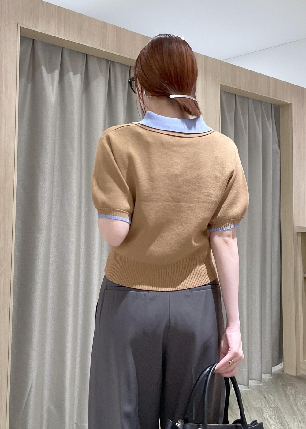 イエロー系のポロシャツ、ブラック系のトートバッグ、グレー系のその他パンツを着用したレディースの春コーディネートの7枚目の写真