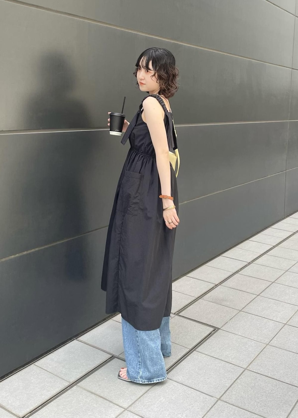 ブラック系のサンダル、ブルー系のデニムパンツを着用したレディースの夏コーディネートの3枚目の写真