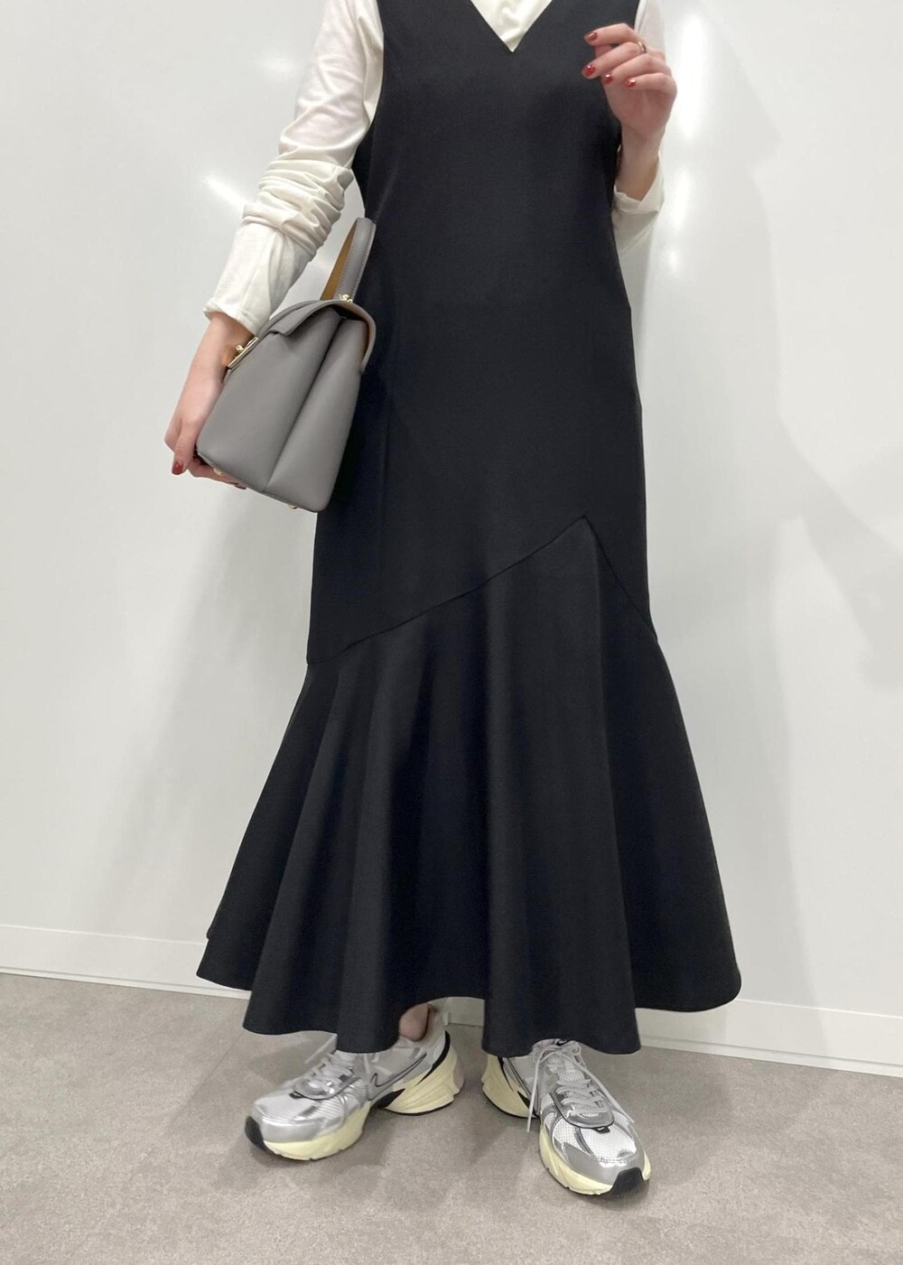 グレー系のハンドバッグ、ブラック系のワンピース、ホワイト系のTシャツ/カットソーを着用したレディースの冬コーディネートの9枚目の写真