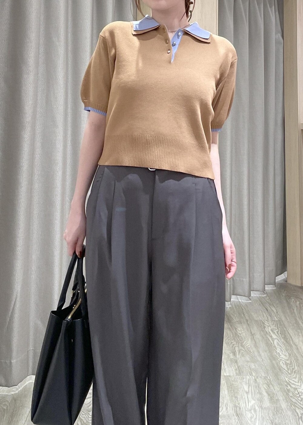 イエロー系のポロシャツ、ブラック系のトートバッグ、グレー系のその他パンツを着用したレディースの春コーディネートの4枚目の写真