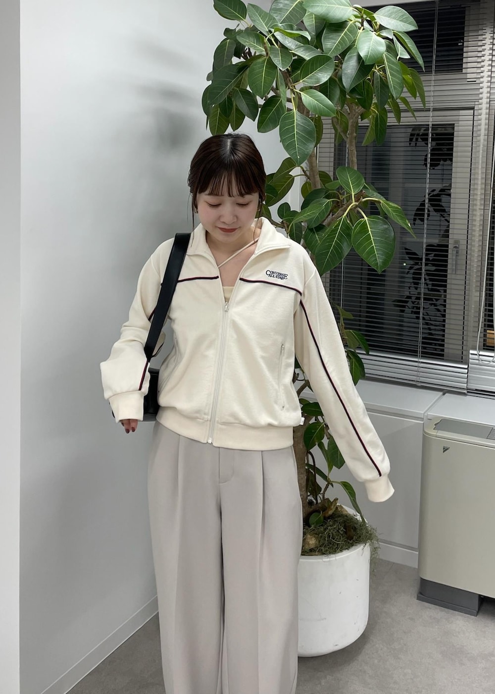ベージュ系のスラックス、ベージュ系のトレンチコート、ブラック系のショルダーバッグを着用したレディースの冬コーディネートの7枚目の写真
