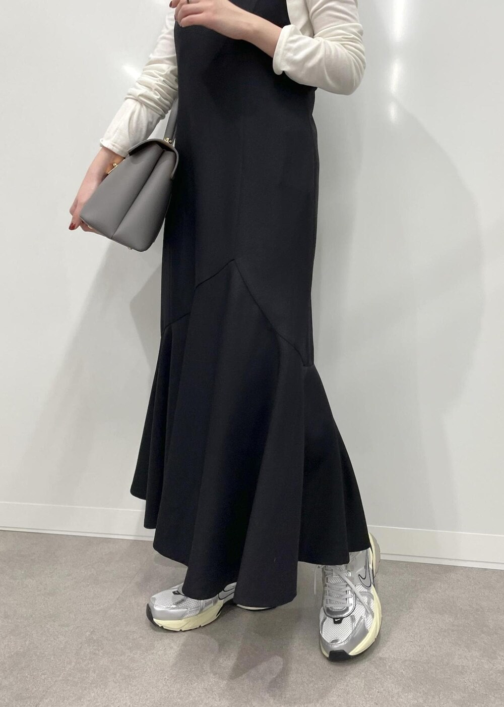 グレー系のハンドバッグ、ブラック系のワンピース、ホワイト系のTシャツ/カットソーを着用したレディースの冬コーディネートの10枚目の写真