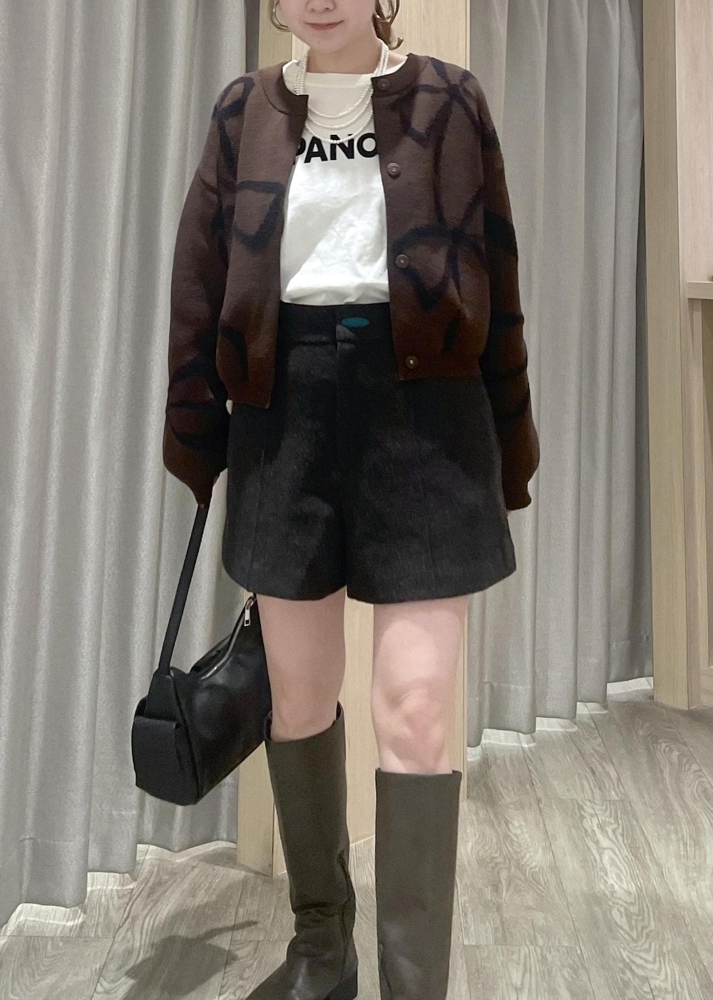 ホワイト系のTシャツ/カットソー、ブラック系のショルダーバッグ、ブラウン系のカーディガン/ボレロを着用したレディースの秋コーディネートの8枚目の写真