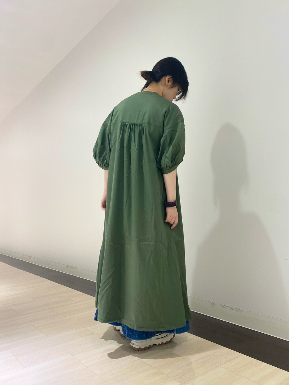 グリーン系のワンピース、ホワイト系のTシャツ/カットソー、ブルー系のデニムスカートを着用したレディースの夏コーディネートの2枚目の写真