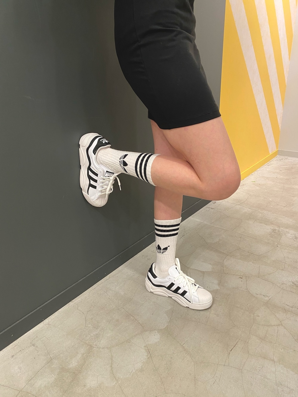 ブラック系のワンピース、ホワイト系のスニーカーを着用したレディースの夏コーディネートの3枚目の写真