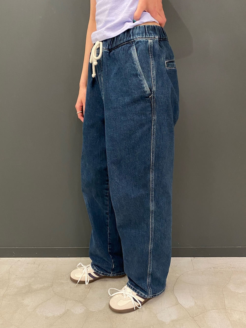 パープル系のトップス、ホワイト系のスニーカーを着用したレディースの春コーディネートの2枚目の写真