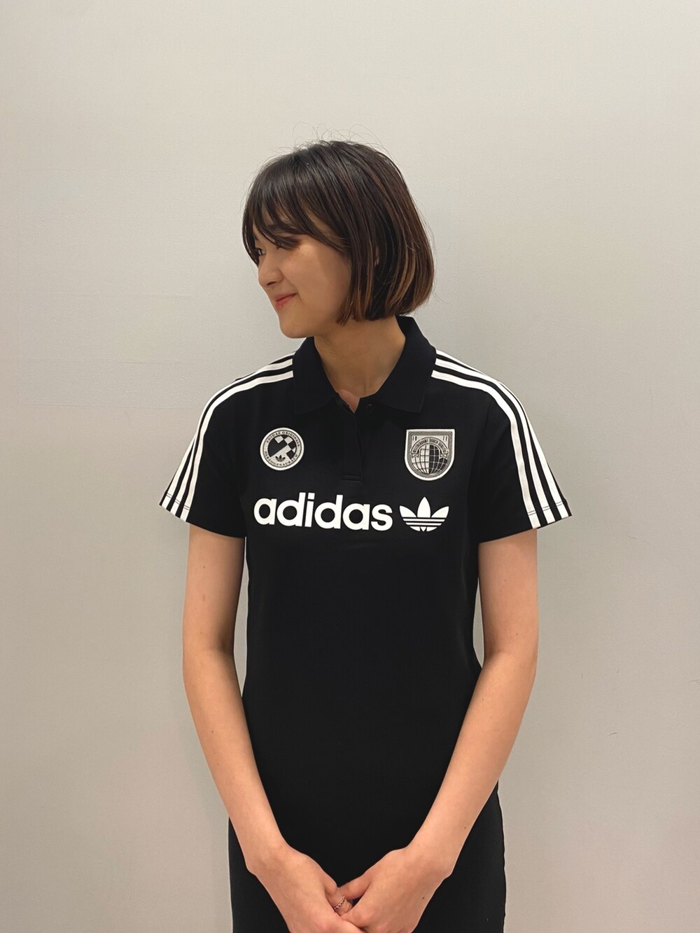 ブラック系のワンピース、ホワイト系のスニーカーを着用したレディースの夏コーディネートの2枚目の写真