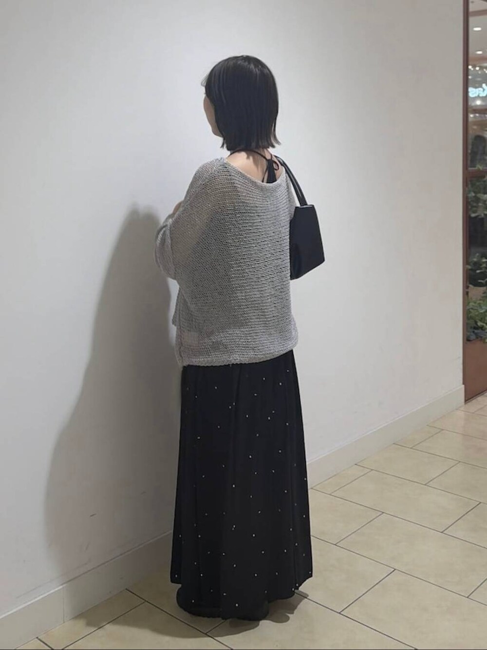 ブラック系のワンピース、ブラック系のショルダーバッグ、グレー系のニット/セーターを着用したレディースの夏コーディネートの3枚目の写真