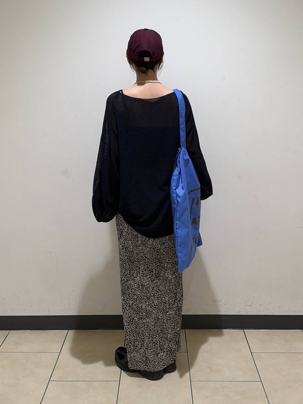 ベージュ系のスカート、ブルー系のトートバッグ、ブルー系のニット/セーターを着用したレディースの春コーディネートの2枚目の写真