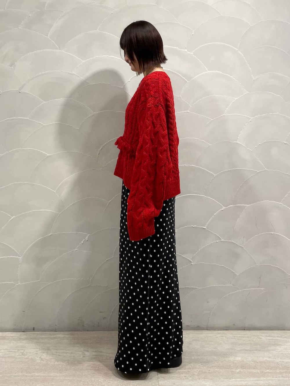 ブラック系のスカート、レッド系のポロシャツを着用したレディースの秋コーディネートの4枚目の写真