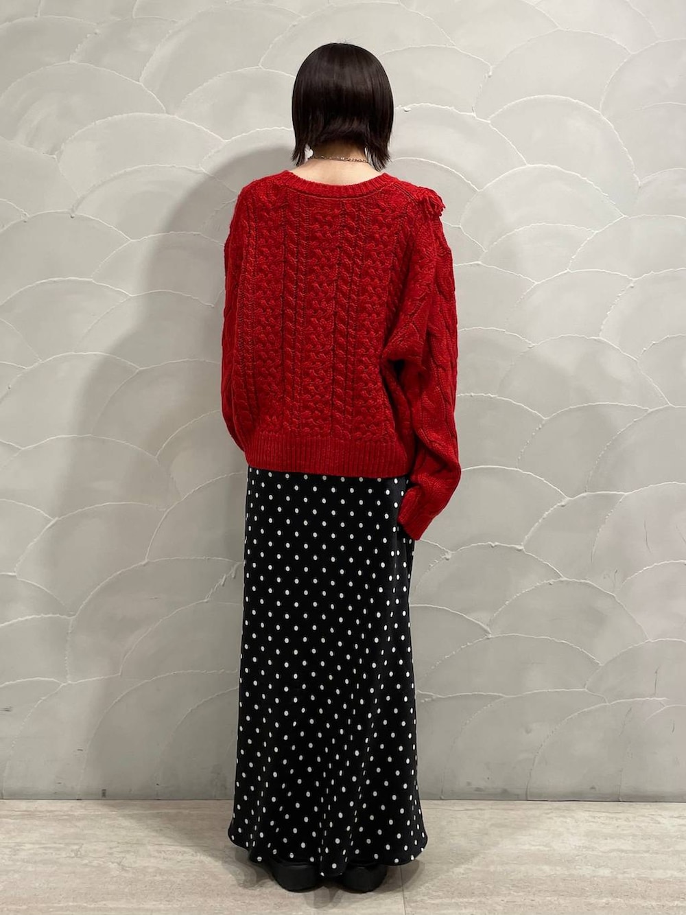 ブラック系のスカート、レッド系のポロシャツを着用したレディースの秋コーディネートの3枚目の写真