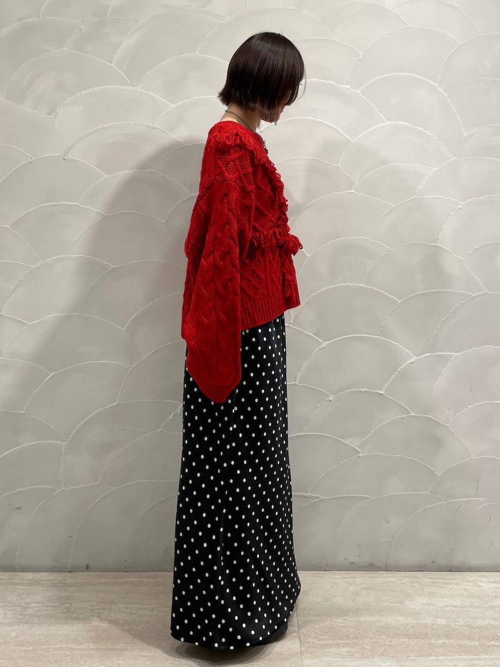 ブラック系のスカート、レッド系のポロシャツを着用したレディースの秋コーディネートの2枚目の写真