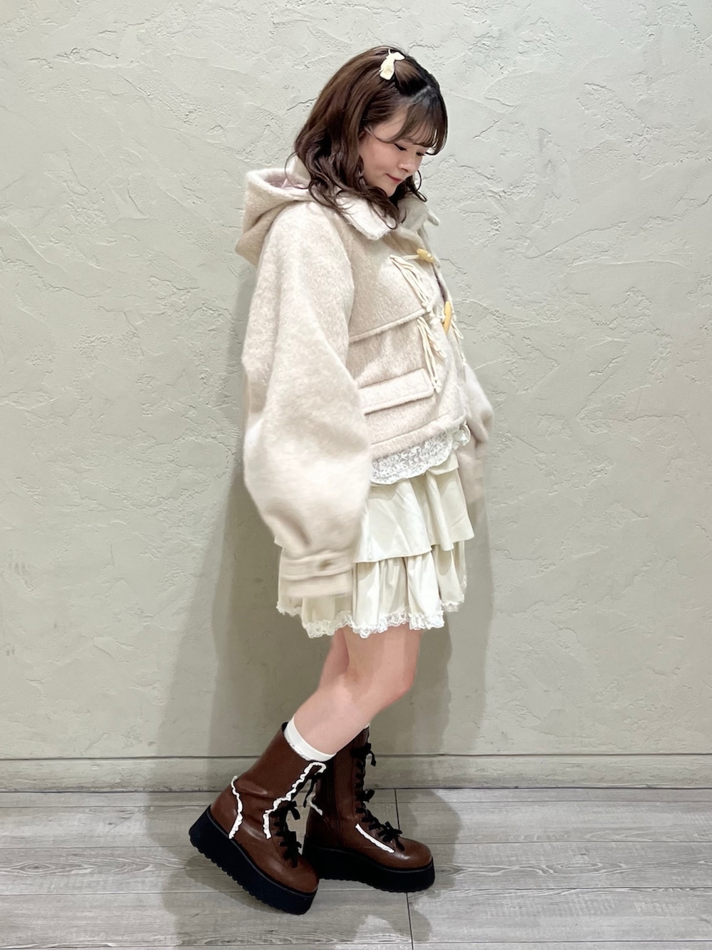 ホワイト系のニット/セーター、ピンク系のダッフルコート、ホワイト系のスカートを着用したレディースの秋コーディネートの3枚目の写真