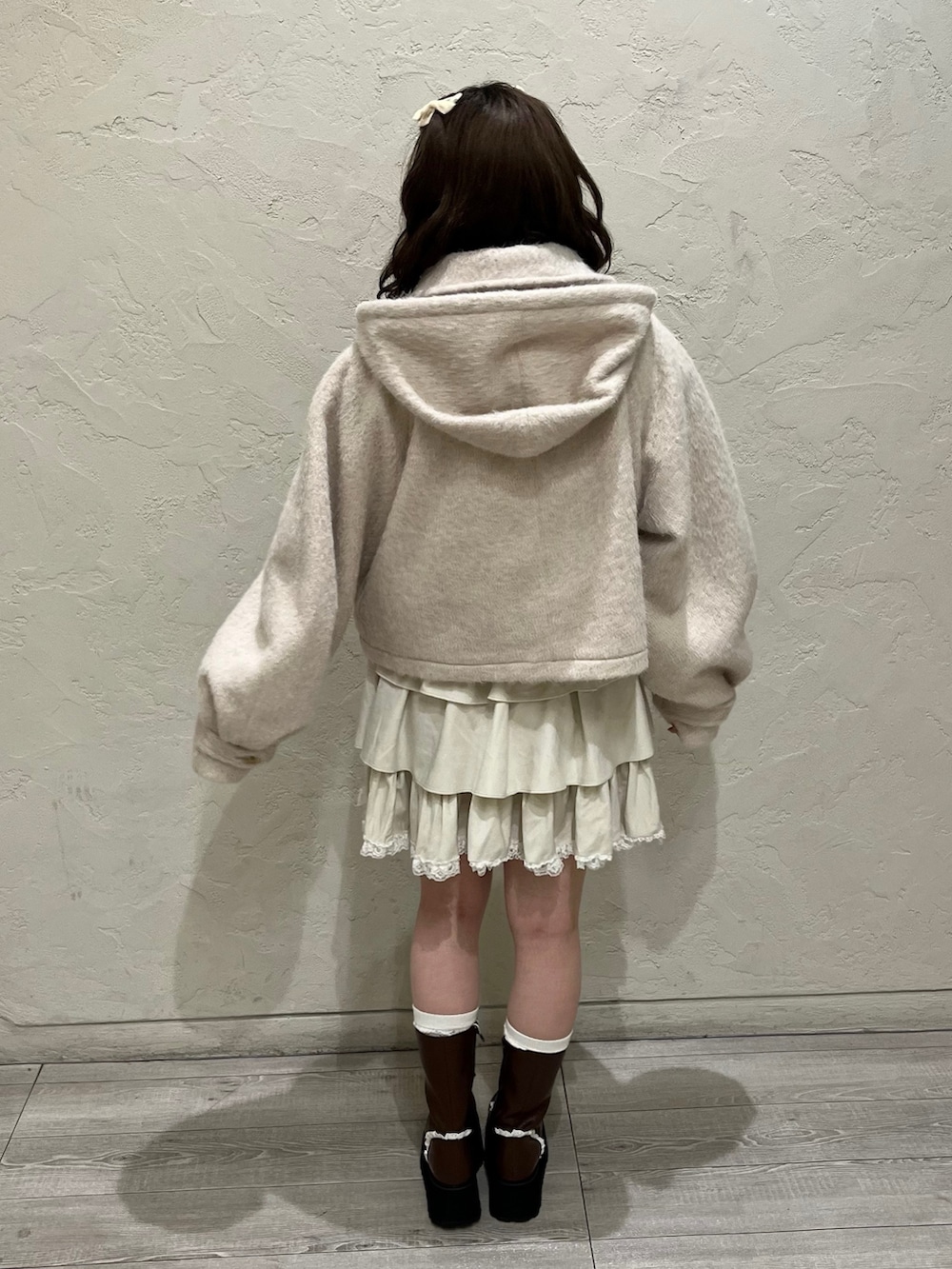 ホワイト系のニット/セーター、ピンク系のダッフルコート、ホワイト系のスカートを着用したレディースの秋コーディネートの4枚目の写真