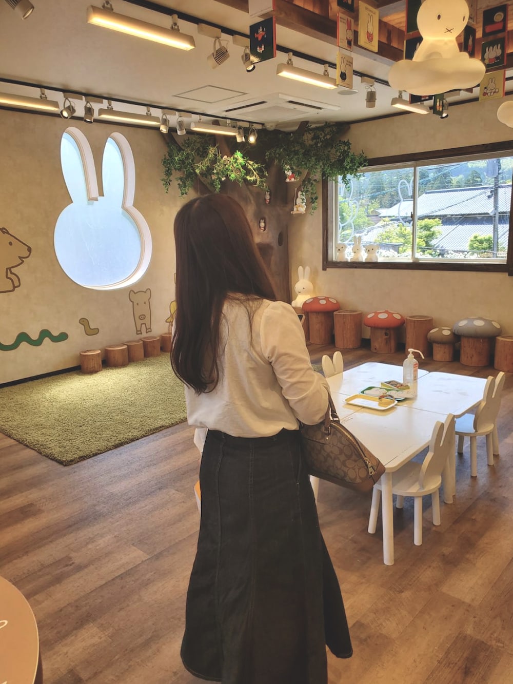 ホワイト系のシャツ/ブラウス、その他のデニムスカート、ブラウン系のハンドバッグを着用したレディースの夏コーディネートの3枚目の写真