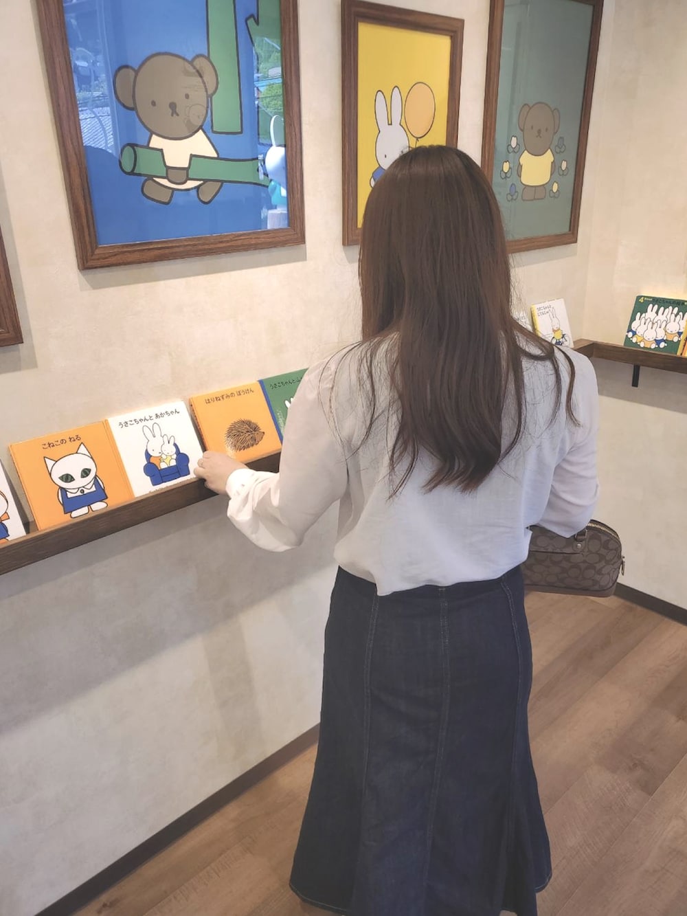 ホワイト系のシャツ/ブラウス、その他のデニムスカート、ブラウン系のハンドバッグを着用したレディースの夏コーディネートの2枚目の写真