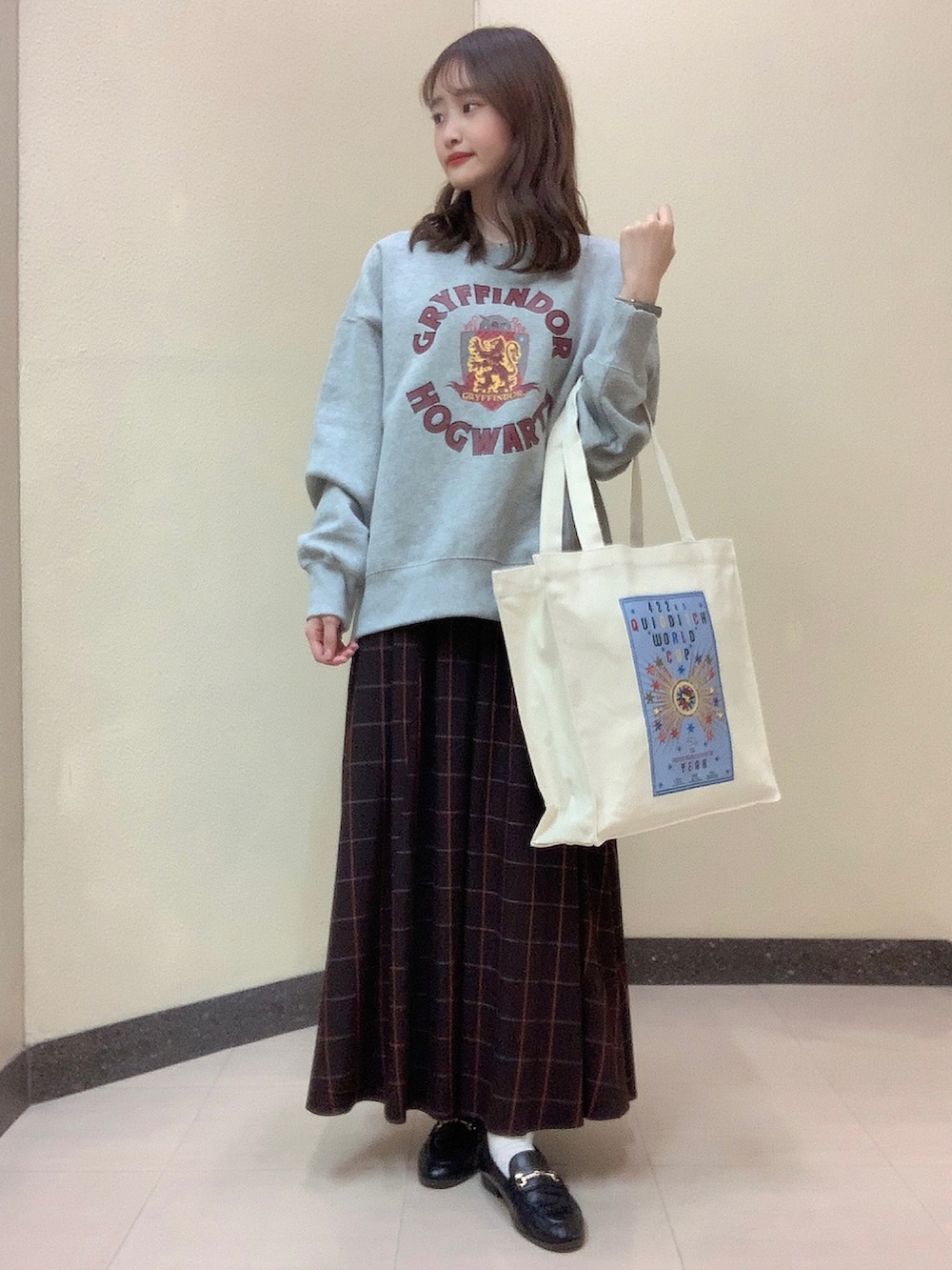 グレー系のスウェット、ホワイト系のトートバッグ、ブラウン系のスカートを着用したレディースの冬コーディネートの2枚目の写真