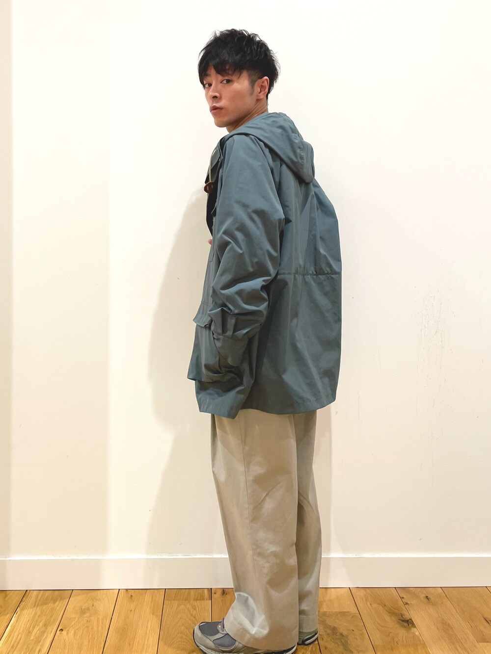 ブルー系のマウンテンパーカー、グリーン系のスウェット、ブラウン系のその他パンツを着用したメンズの冬コーディネートの2枚目の写真