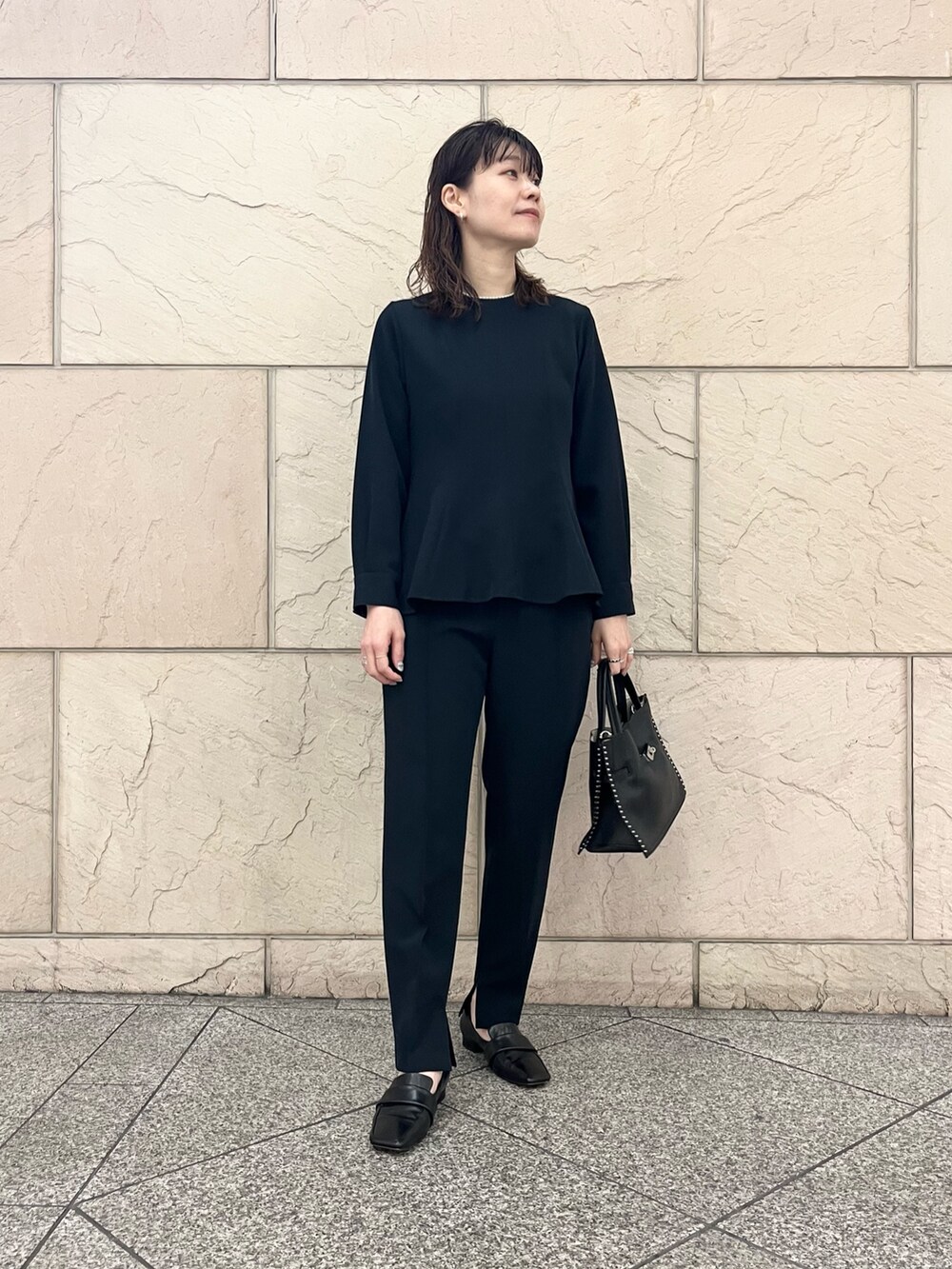 ブラック系のショルダーバッグ、ブラック系のその他シューズ、ブルー系のセットアップを着用したレディースの冬コーディネートの2枚目の写真