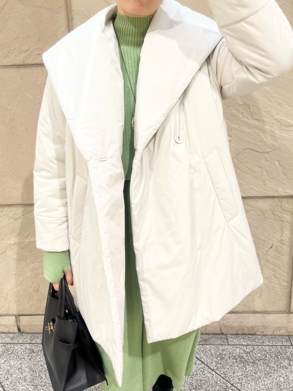 グリーン系のワンピース、ベージュ系のダウンジャケット/コート、ゴールド系のネックレスを着用したレディースの冬コーディネートの4枚目の写真