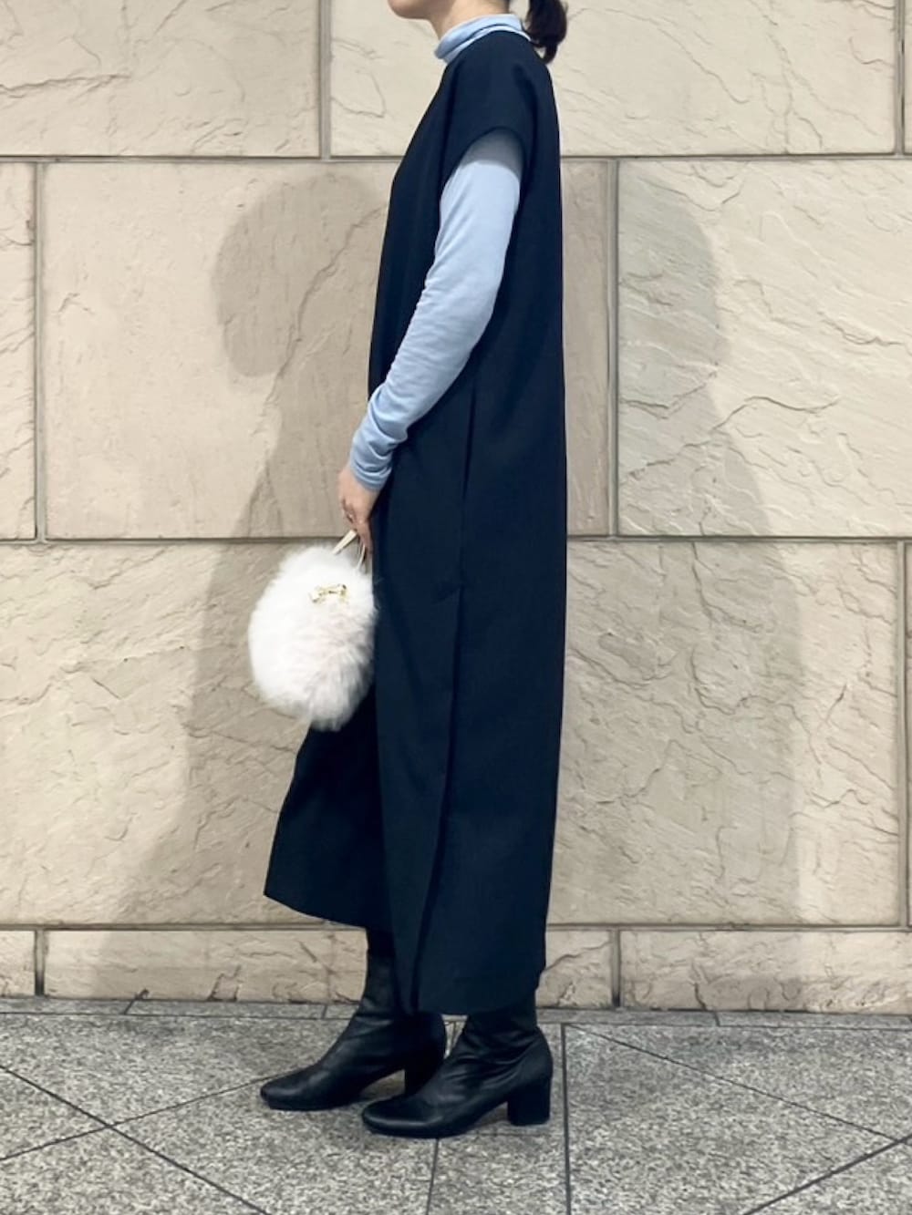 ホワイト系のハンドバッグ、ブルー系のワンピース、ブルー系のTシャツ/カットソーを着用したレディースの冬コーディネートの2枚目の写真