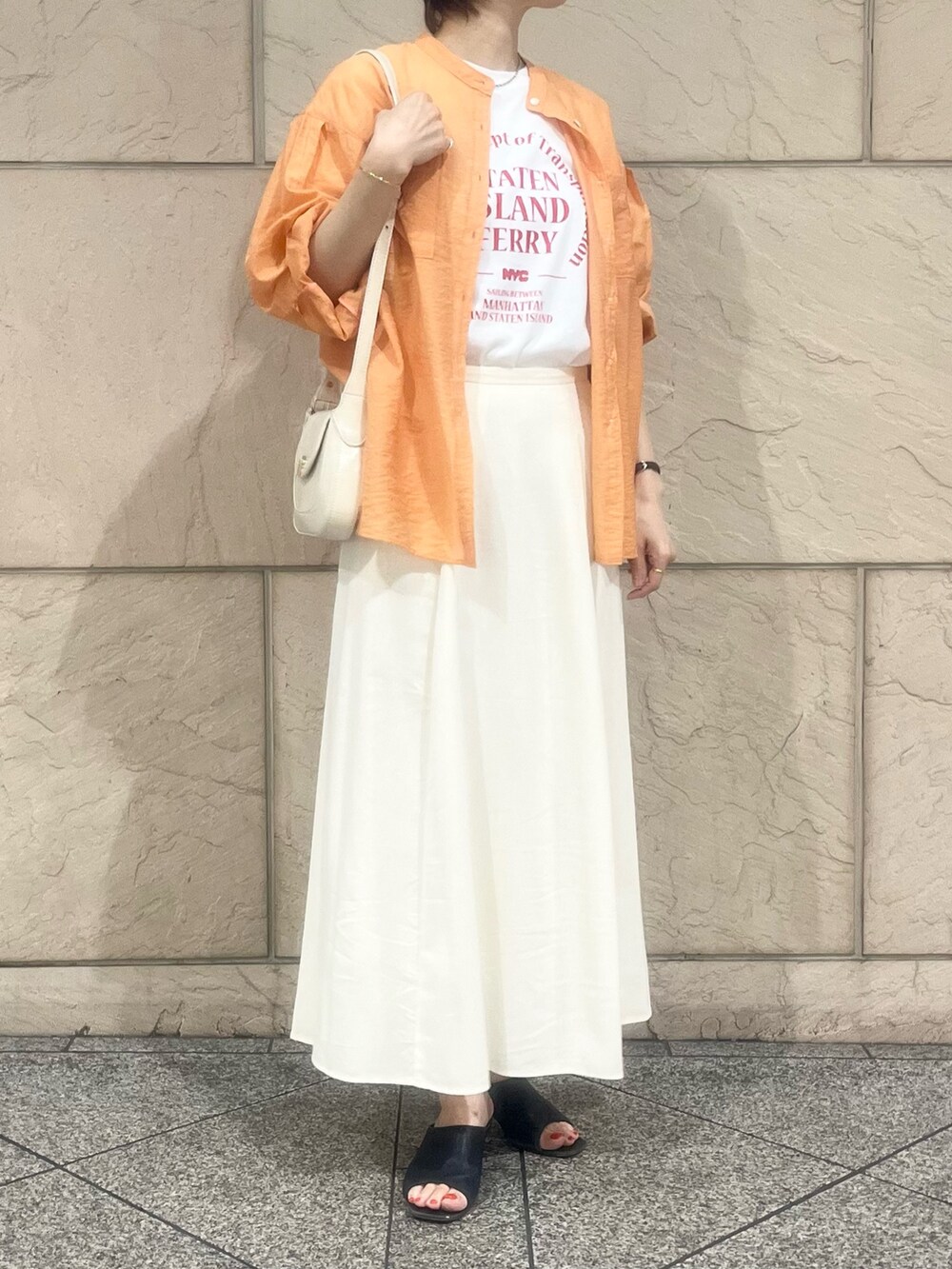 ホワイト系のスカート、オレンジ系のシャツ/ブラウス、ホワイト系のTシャツ/カットソーを着用したレディースの夏コーディネートの2枚目の写真