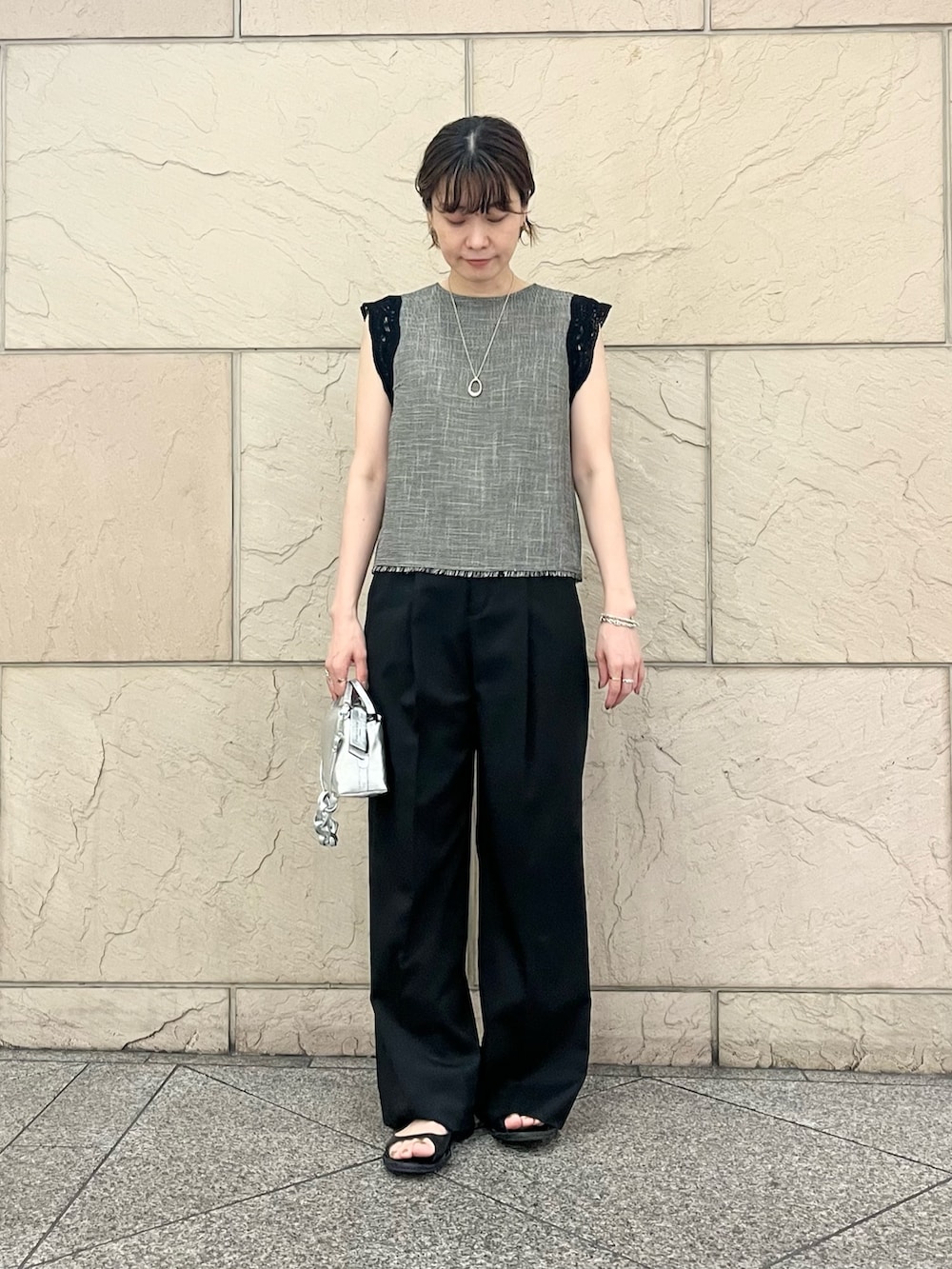 ブラック系のシャツ/ブラウス、シルバー系のハンドバッグ、ブラック系のサンダルを着用したレディースの夏コーディネートの6枚目の写真
