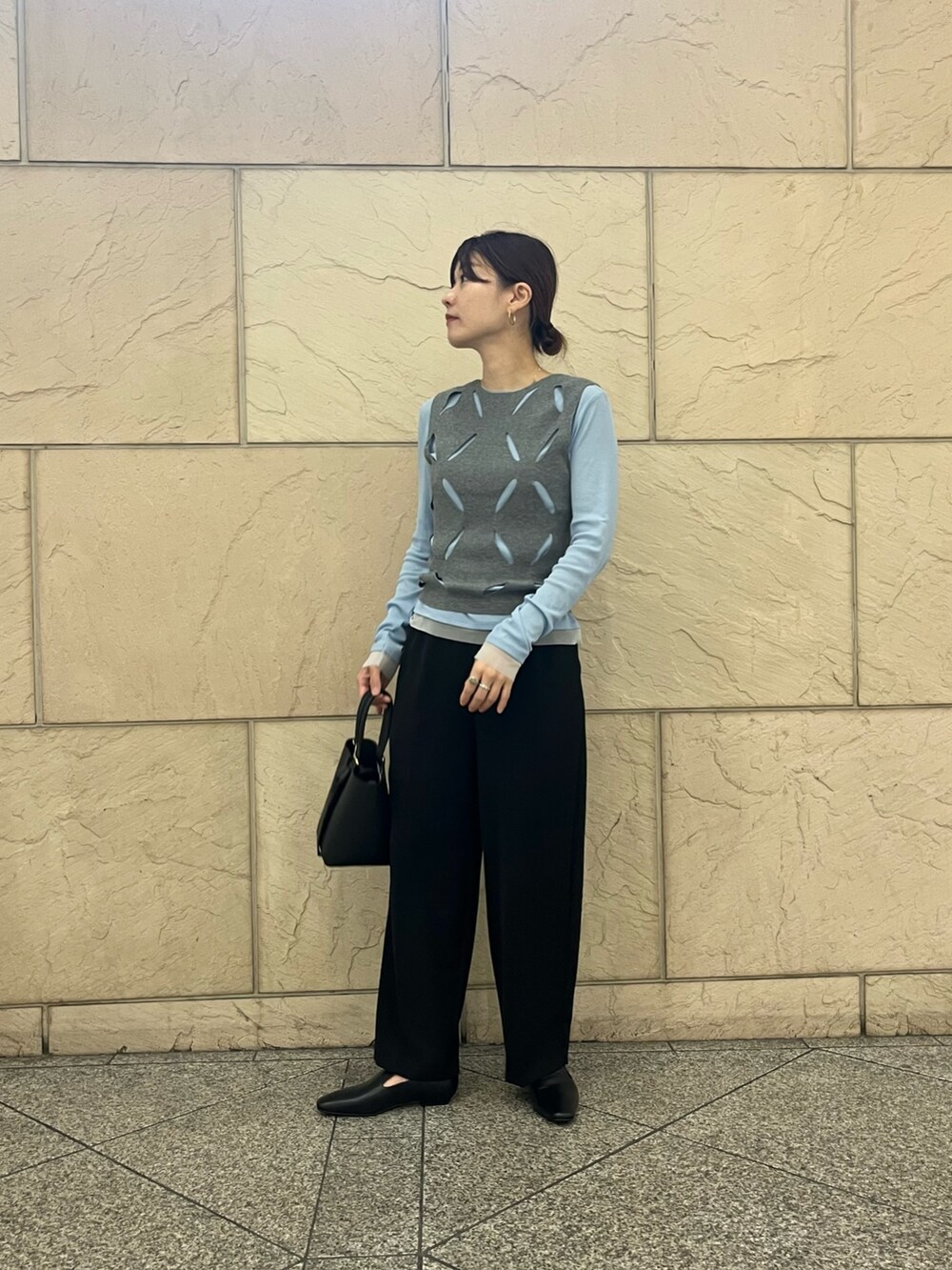 ブラック系のローファー、ブラック系のハンドバッグ、ホワイト系のニット/セーターを着用したレディースの秋コーディネートの4枚目の写真