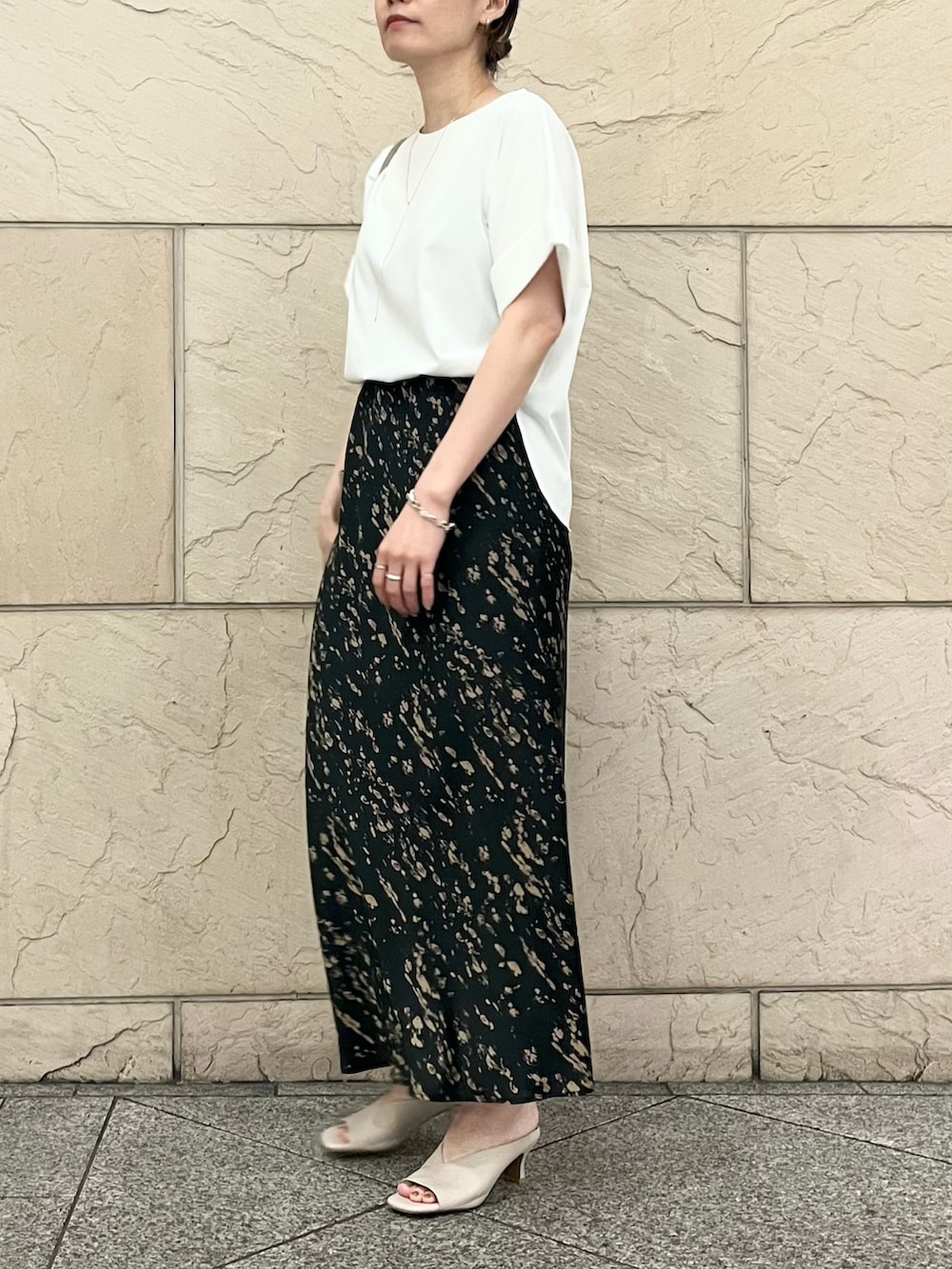 ホワイト系のTシャツ/カットソー、グレー系のハンドバッグ、ブラック系のスカートを着用したレディースの夏コーディネートの3枚目の写真