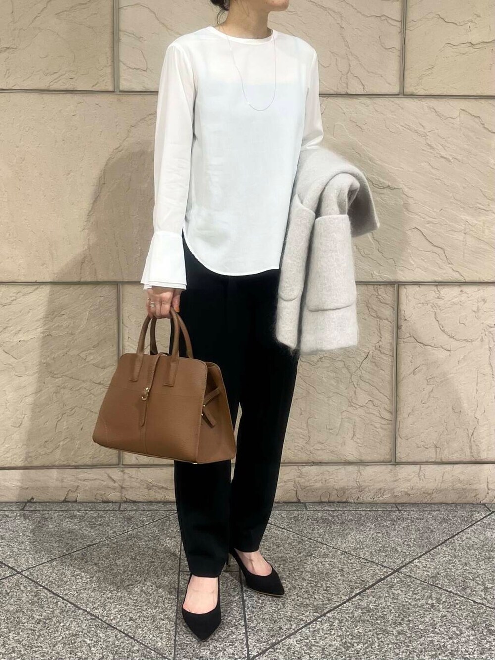 ホワイト系のシャツ/ブラウス、ブラウン系のハンドバッグ、ベージュ系のその他アウターを着用したレディースの秋コーディネートの4枚目の写真