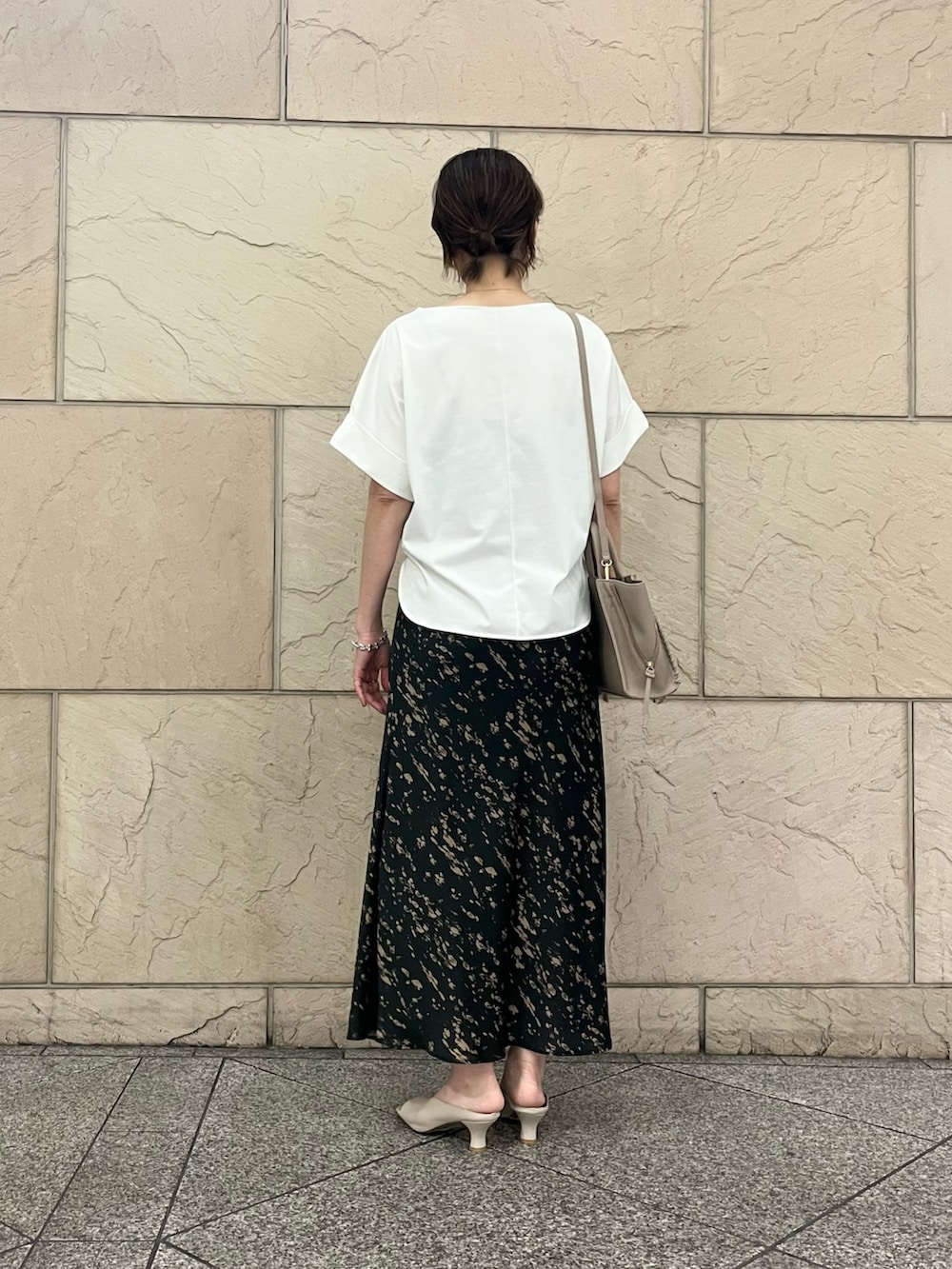 ホワイト系のTシャツ/カットソー、グレー系のハンドバッグ、ブラック系のスカートを着用したレディースの夏コーディネートの5枚目の写真