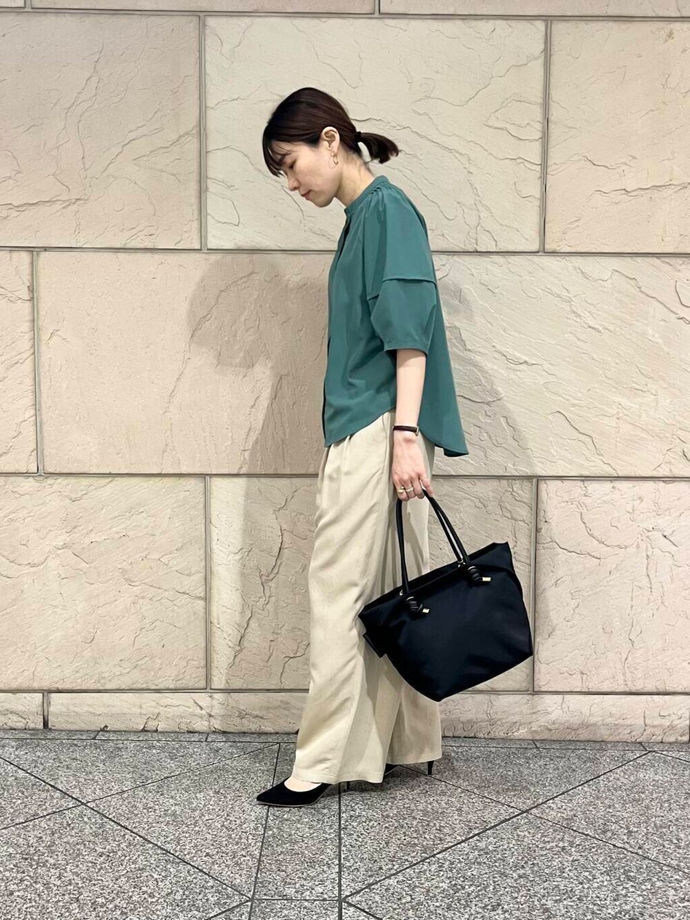 ブラック系のパンプス、ブラック系のトートバッグ、グリーン系のシャツ/ブラウスを着用したレディースの春コーディネートの3枚目の写真