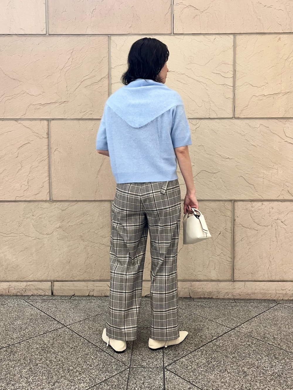ブルー系のニット/セーター、ホワイト系のショルダーバッグ、ベージュ系のその他パンツを着用したレディースの秋コーディネートの3枚目の写真