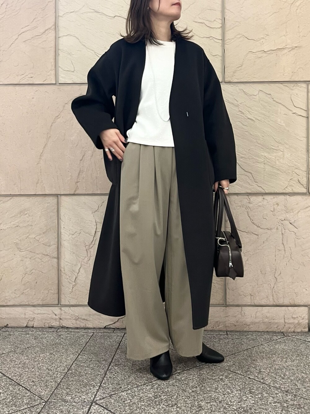 グレー系のその他アウター、ブラウン系のハンドバッグ、ベージュ系のその他パンツを着用したレディースの秋コーディネートの4枚目の写真