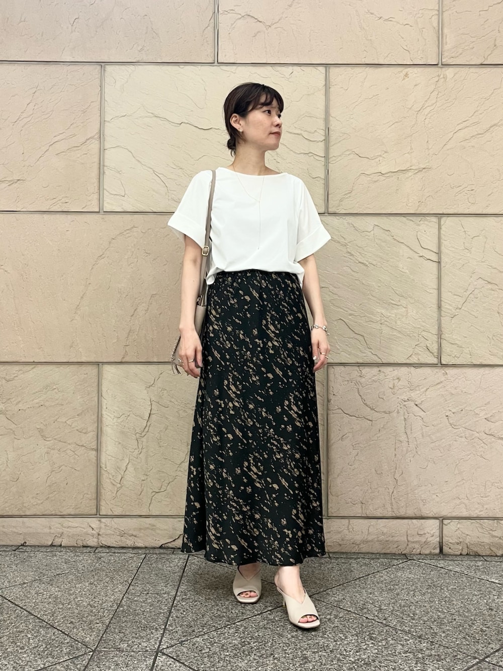 ホワイト系のTシャツ/カットソー、グレー系のハンドバッグ、ブラック系のスカートを着用したレディースの夏コーディネートの2枚目の写真
