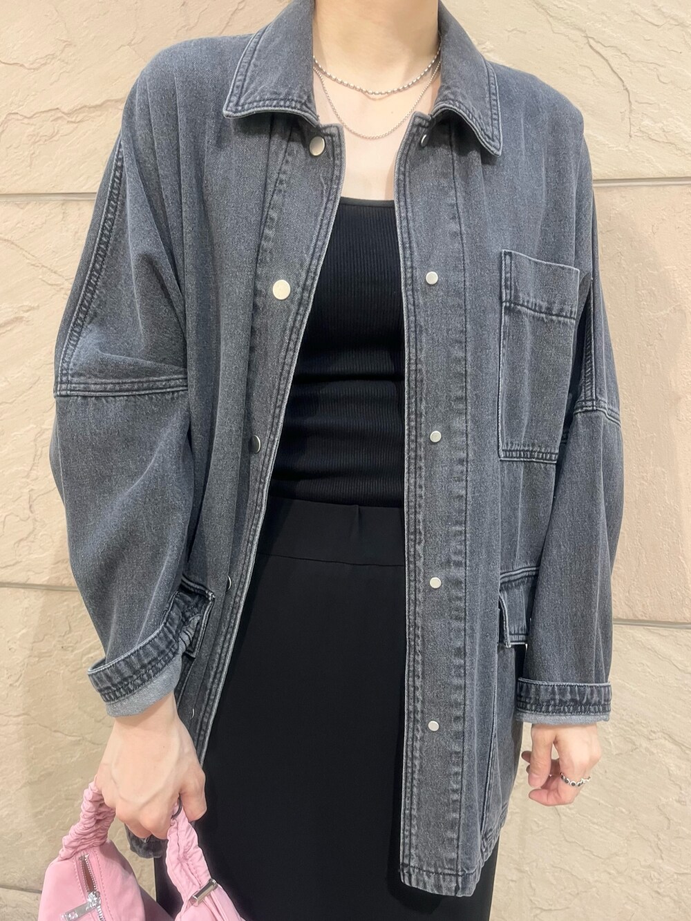 グレー系のデニムジャケット、レッド系のショルダーバッグ、ブラック系のキャミソールを着用したレディースの夏コーディネートの3枚目の写真